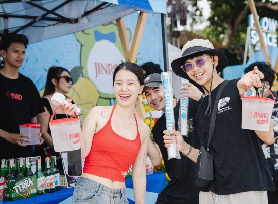 새멧 인 러브 뮤직 페스티벌 2025에서 참가자들이 진로 굿즈를 들고 있다.